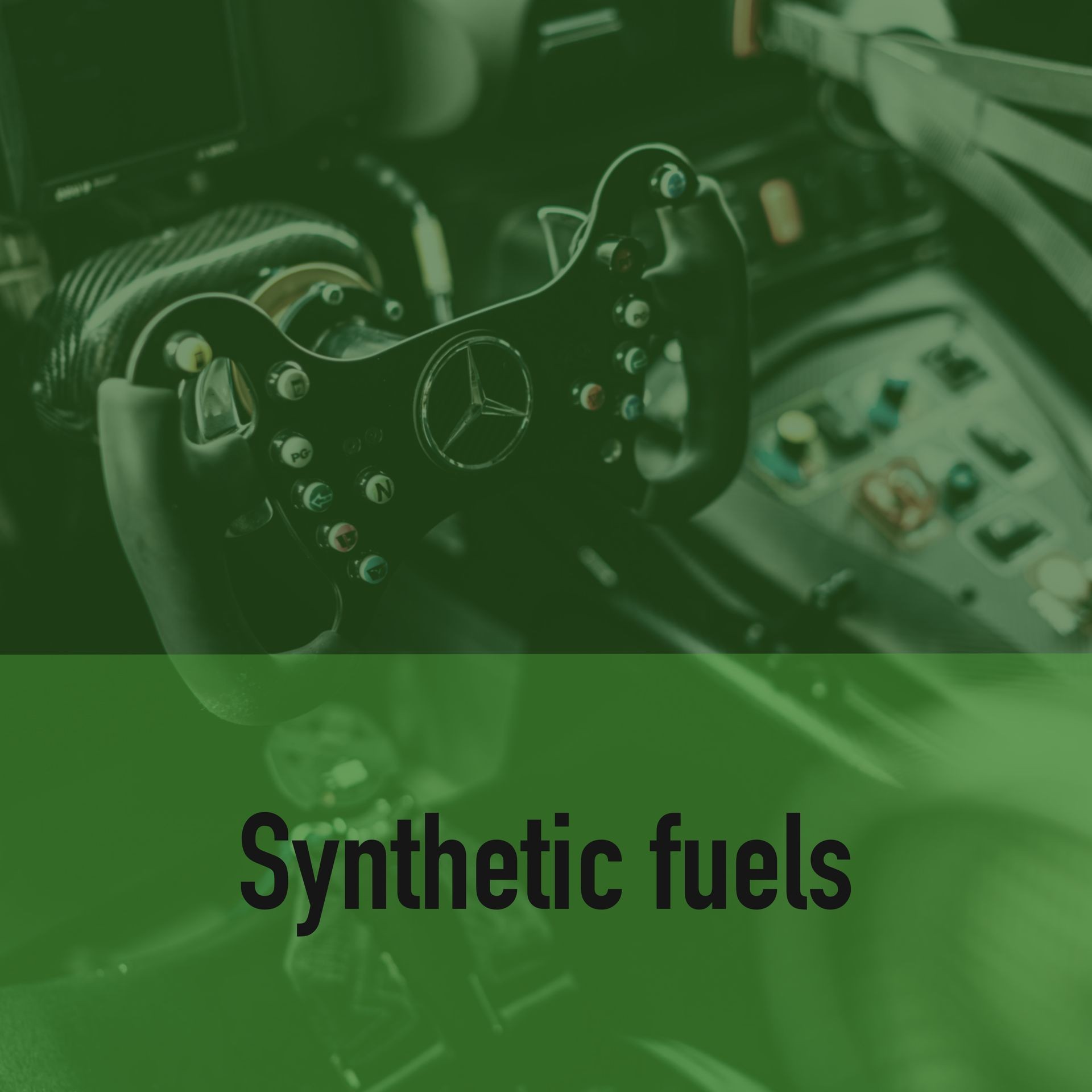 Close-up of a car steering wheel with 'Synthetic fuels' text overlay.